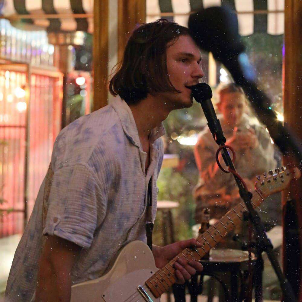 a man playing a guitar in front of a microphone
