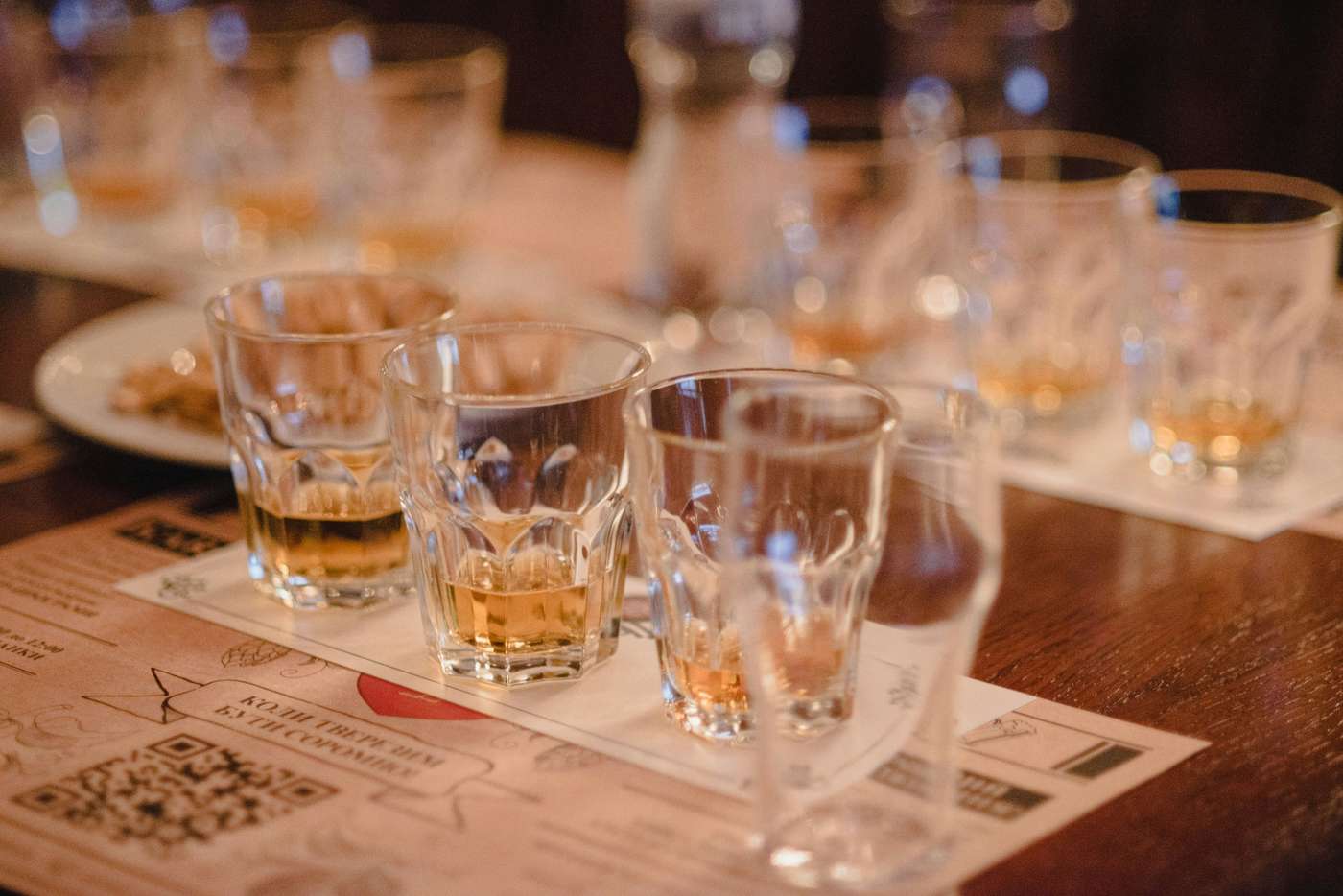 APM0T3kaNJY a wooden table topped with glasses filled with liquid